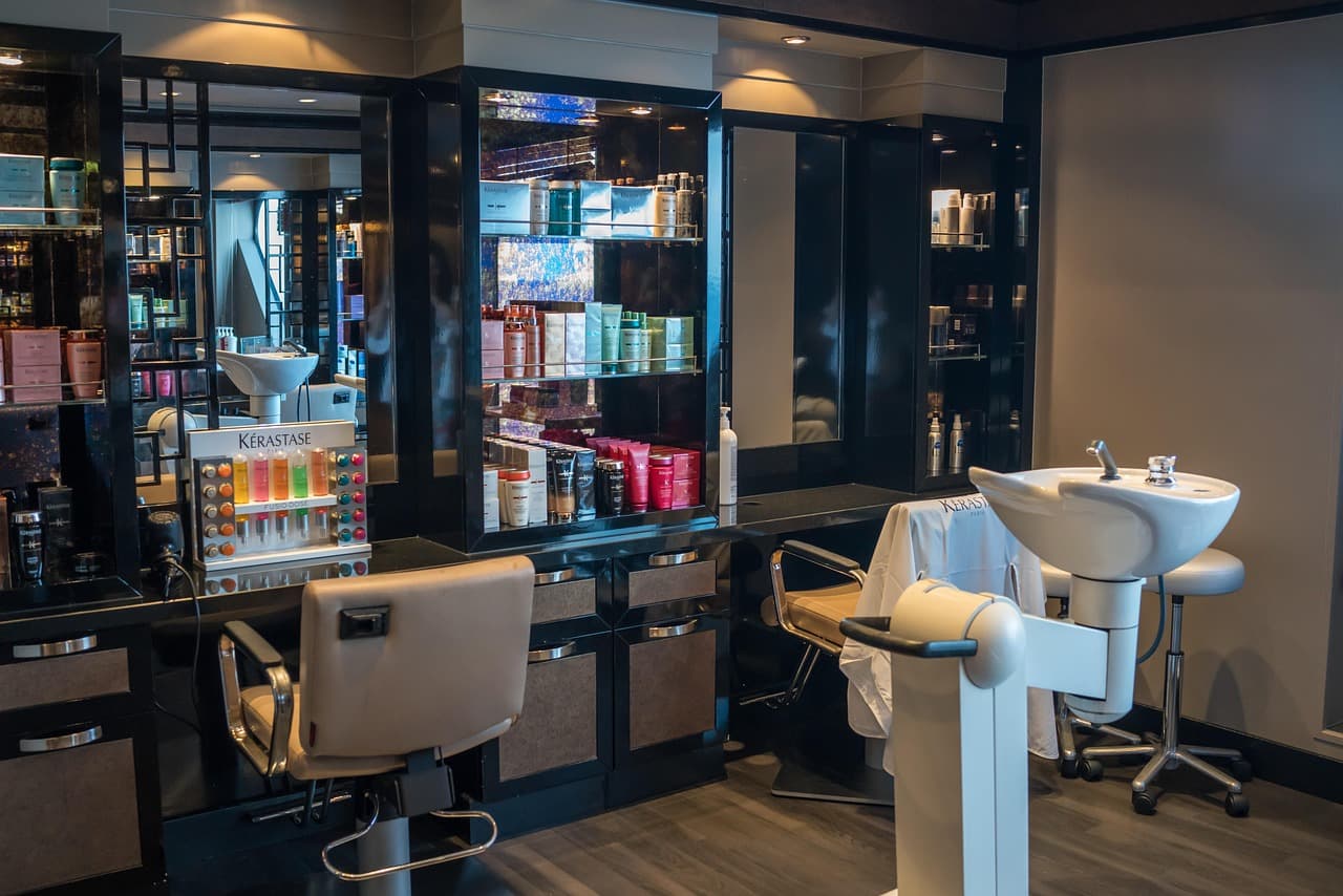 A salon chair beside a backwash basin