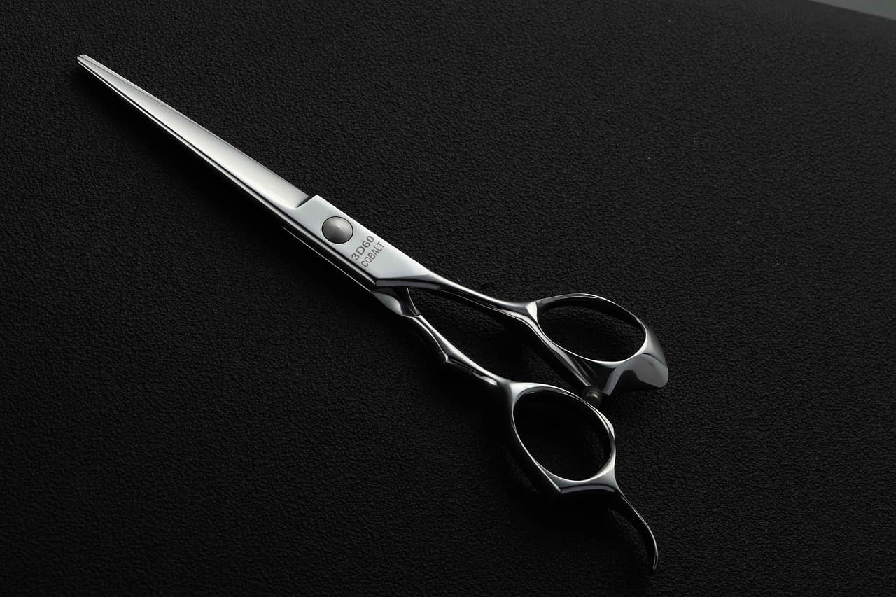 A pair of barber’s scissors on a dark cloth