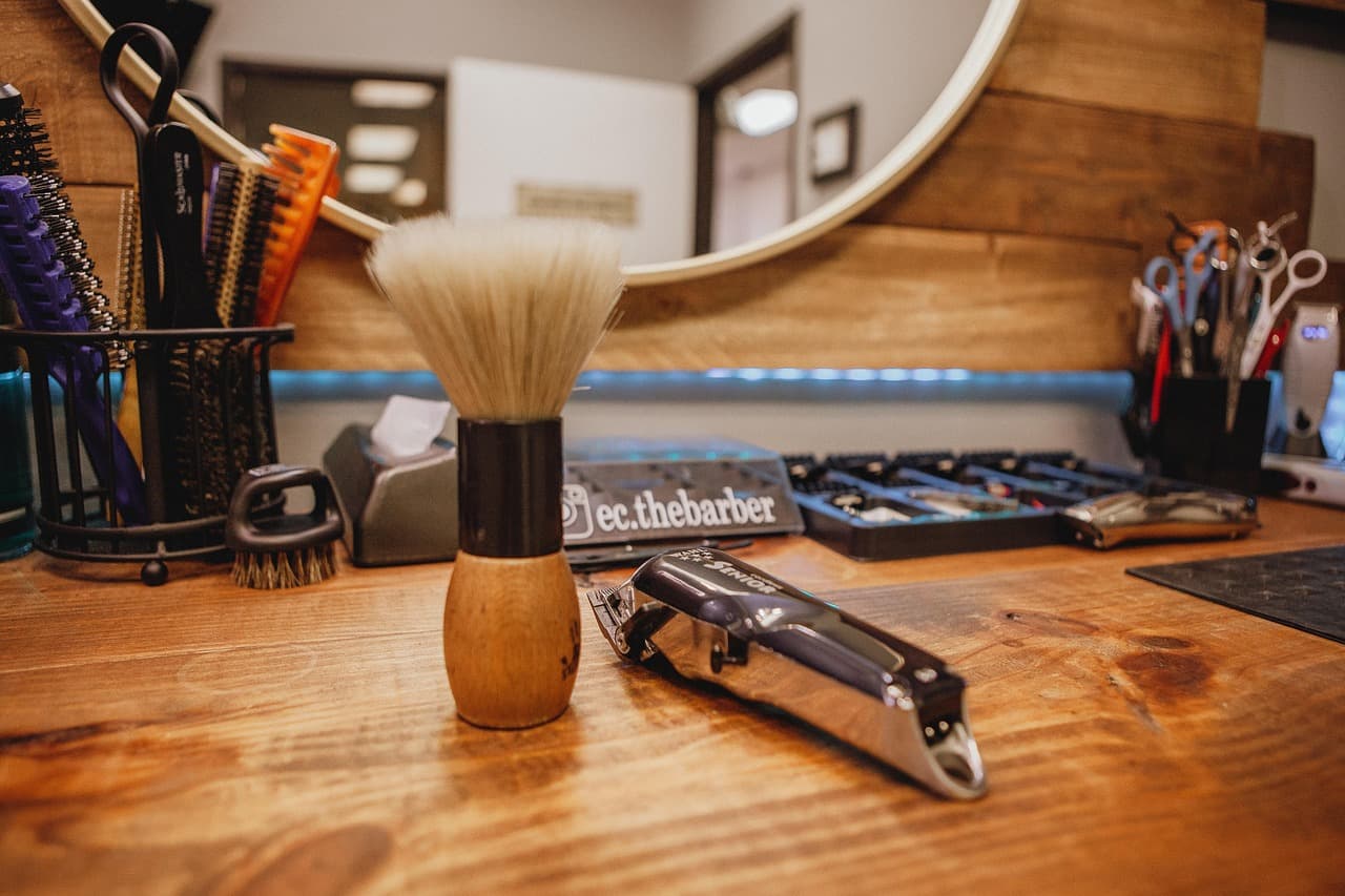 A shaving brush and tools laid out on a wooden counter